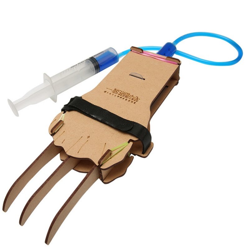 Child wearing a DIY Hydraulic Claw STEM engineering kit controlled by water-powered hydraulic syringes.